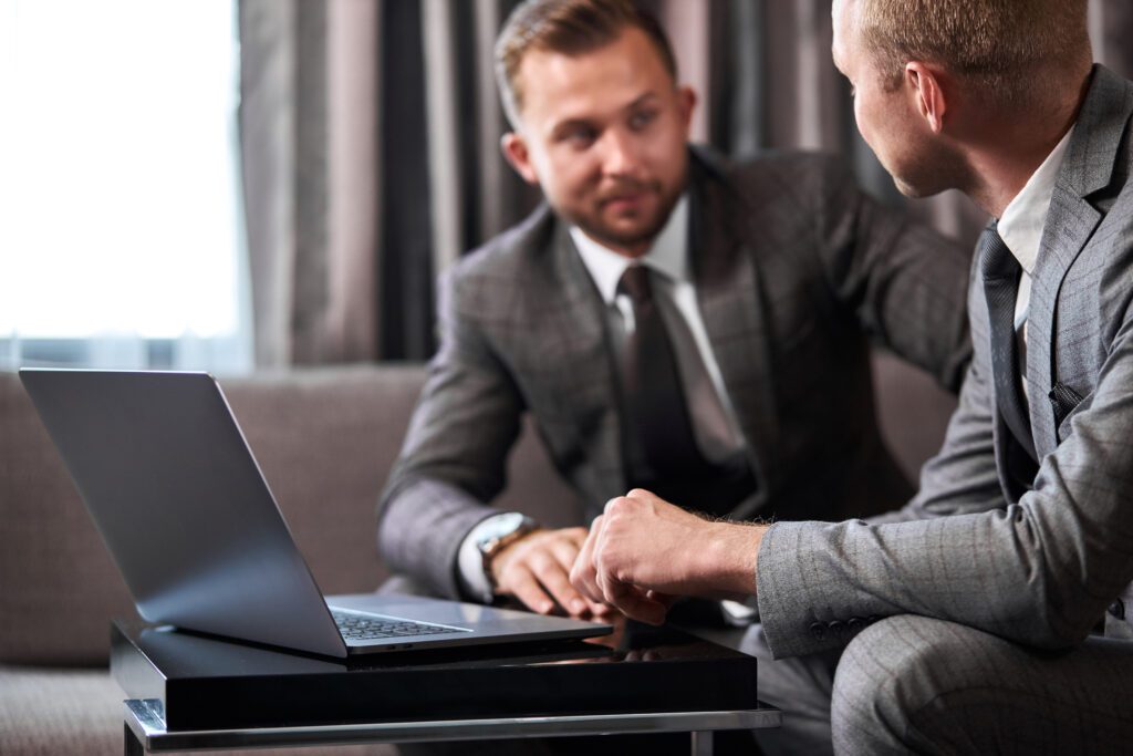 men in suits in a meeting looking at computer, IT consultancy